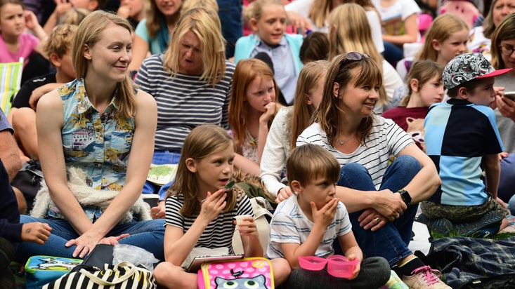 Audience watching a live performance of 'The Secret Garden' outdoors at Cliveden, Buckinghamshire